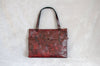 Handmade red leather bag with black wash and rivet belt