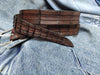 Brown leather belt with handmade cuts in the shape and texture of a crocodile