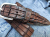 Brown leather belt with handmade cuts in the shape and texture of a crocodile