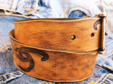 A brown leather belt with tribal that made from ishaor logo and vintage finish that give to the belt western rodeo style