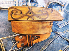 A brown leather belt with tribal that made from ishaor logo and vintage finish that give to the belt western rodeo style