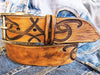 A brown leather belt with tribal that made from ishaor logo and vintage finish that give to the belt western rodeo style