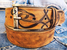 A brown leather belt with tribal that made from ishaor logo and vintage finish that give to the belt western rodeo style