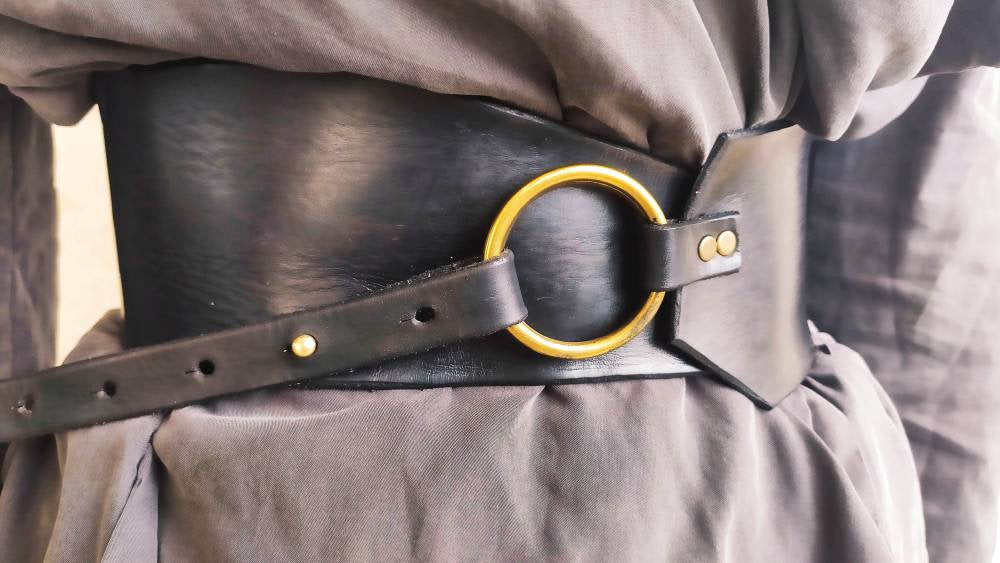 Black leather waist belt with asymmetrical design and bronze Ring